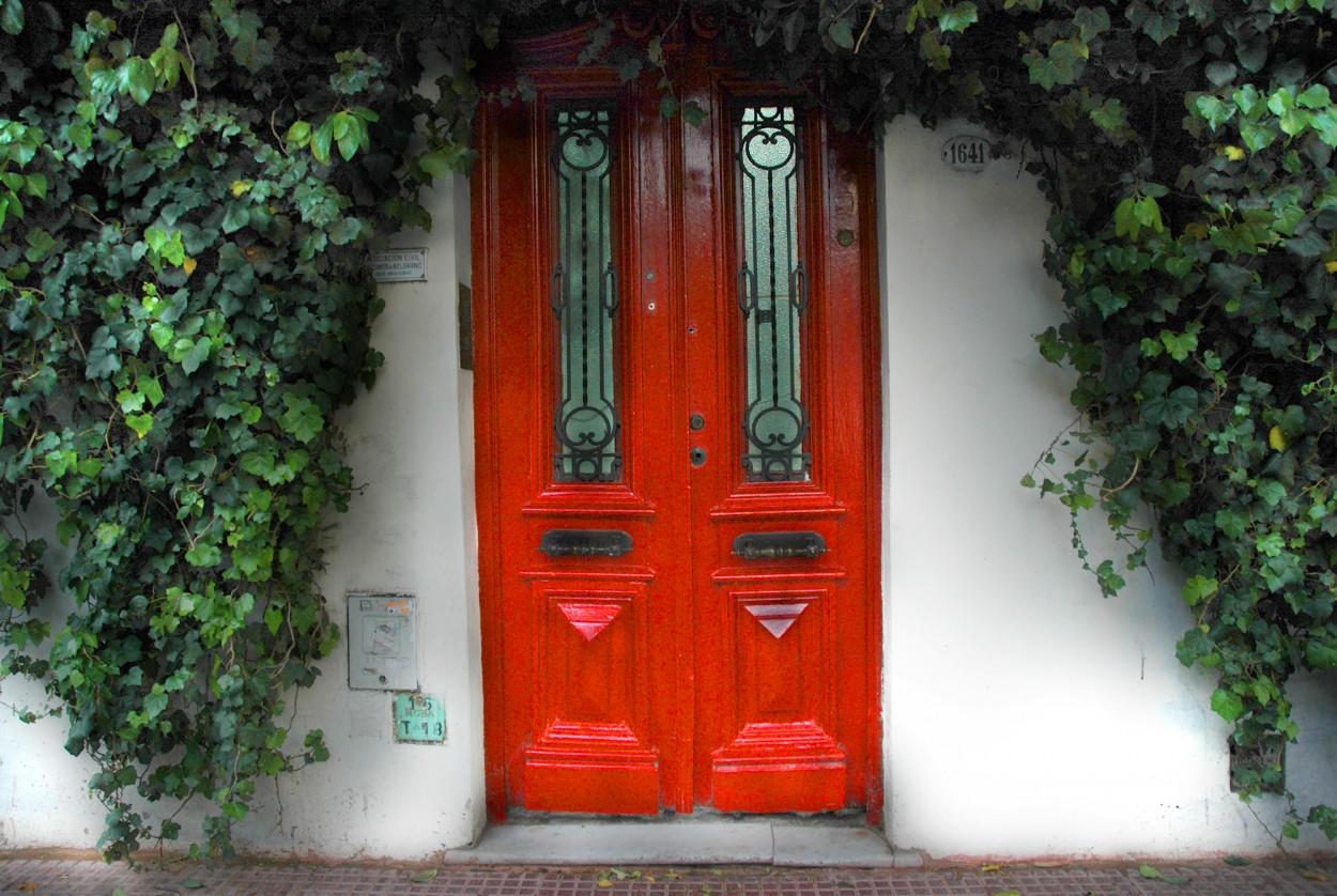 Puerta roja o verdes hojas